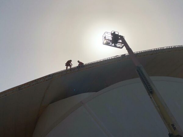 Three Megarme technicians on the roof of a pavilion doing an anchor bolt installation