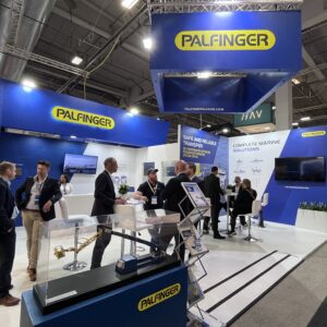 PALFINGER MARINE's stand at Nor-Shipping, filled with people in deep conversations.