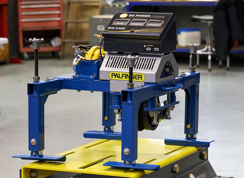 PALFINGER lifeboat engine test stand - a blue object made of aluminum with four legs and a display on top.