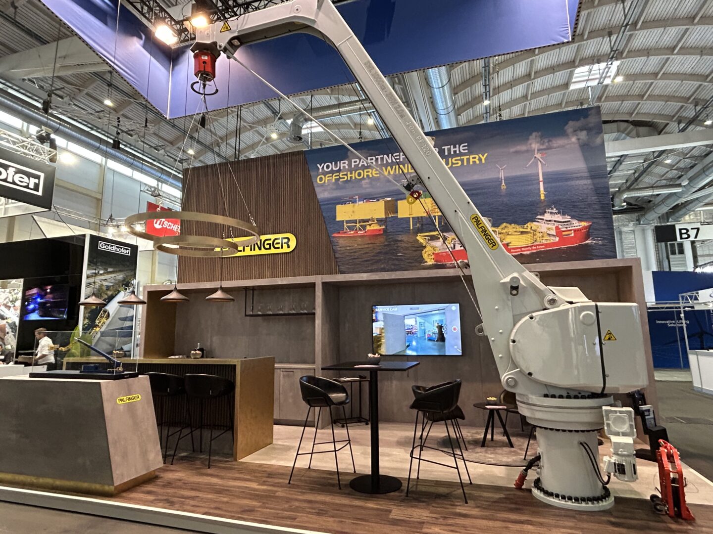 PALFINGER MARINE exhibition stand at the Wind Energy Hamburg 2024, with a fixed boom crane in the center