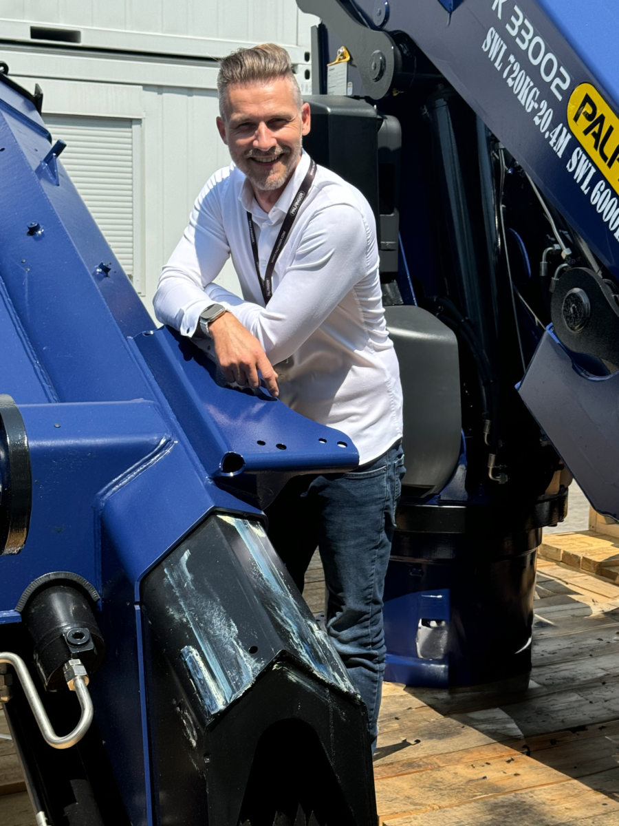 Our regional manager standing next to a marine crane at the dispatch area in Maribor